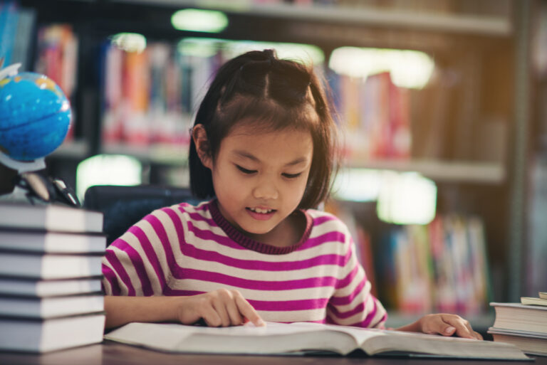 Portrait of a student child girl studying at library,Learning Concept